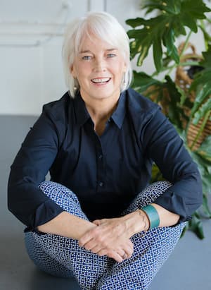 Therapist Jamie Brennan's professional headshot indoors with plants around her