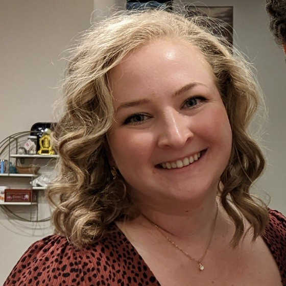 Photo of Provider Nora Claire Kunzmann, smiling with blond curly hair.